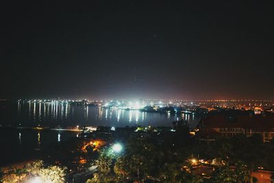 Illuminated city against sky at night