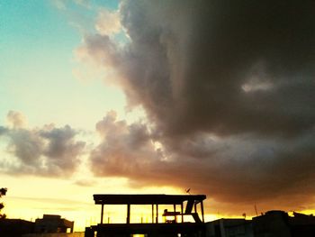 Silhouette city against sky at sunset