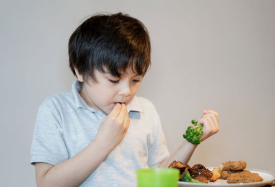 Boy holding ice cream on table