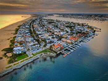 High angle view of cityscape at beach against sky during sunset