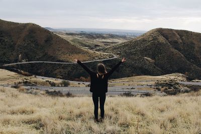 Rear view of woman on mountain against sky