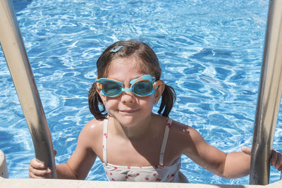 Portrait of young woman swimming in pool