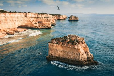 Scenic view of rock formation in sea against sky