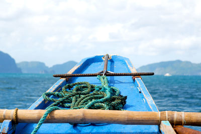 Close-up of rope tied on bollard against sky