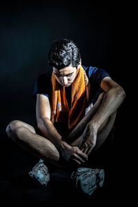 Man sitting against black background