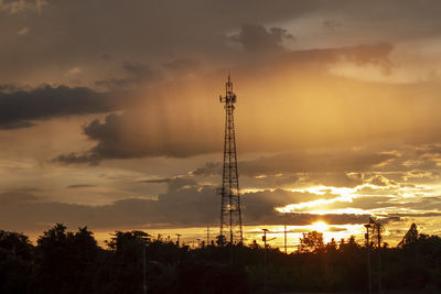 Silhouette of electricity pylon against sky during sunset