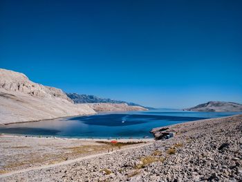 Scenic view of beach against clear blue sky