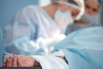 Midsection of doctor examining patient in hospital