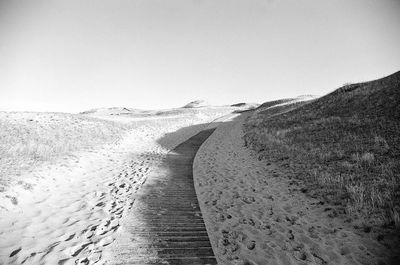 Narrow wooden pathway on sandy beach