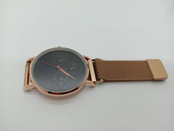 Close-up of clock on table against white background