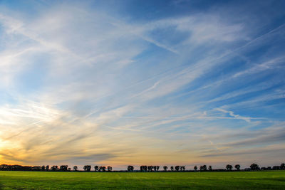 Scenic view of field against sky during sunset