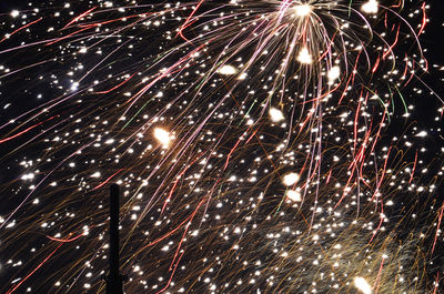 Low angle view of firework display at night