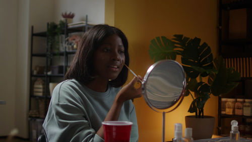 Side view of young woman working at home