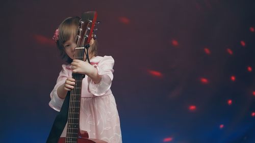 Midsection of woman playing guitar