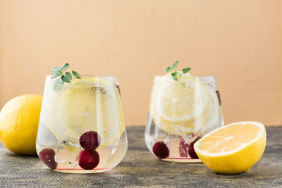 Summer refreshing cold cocktail with lemon and cherry - hard seltzer in glasses on the table