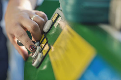 Cropped image of mechanic's hand pressing button on machine in auto repair shop