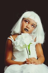 Portrait of woman holding white flower