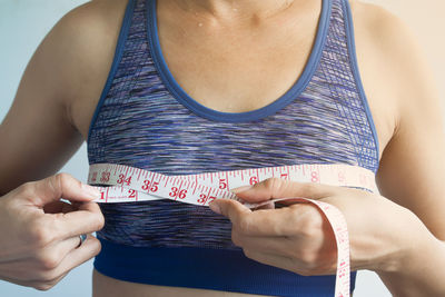 Midsection of woman measuring tape measure