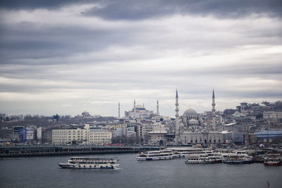 Boats in river with city in background