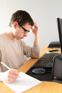 Man using mobile phone while sitting on table
