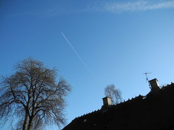 Low angle view of vapor trail against clear blue sky