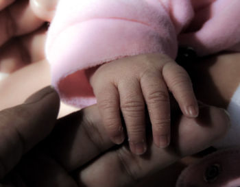 Close-up of mother holding baby hands