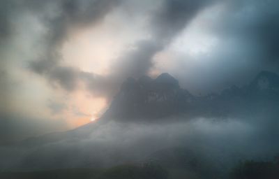 Scenic view of mountains against cloudy sky