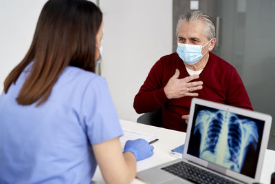 Midsection of woman using laptop at office