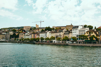 Buildings in city against cloudy sky