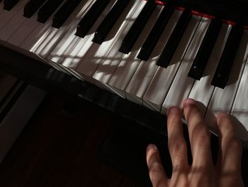 High angle view of hands playing piano