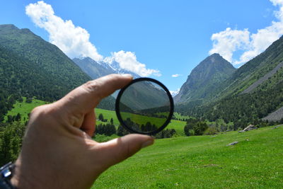 Cropped hand holding loop against mountains