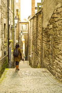 Rear view of man walking in front of building