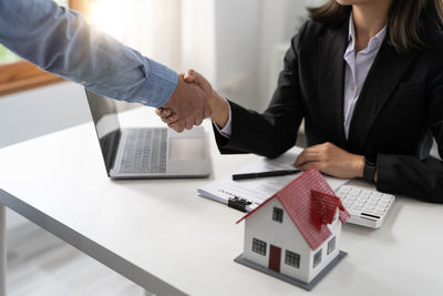 Business colleagues shaking hands in office