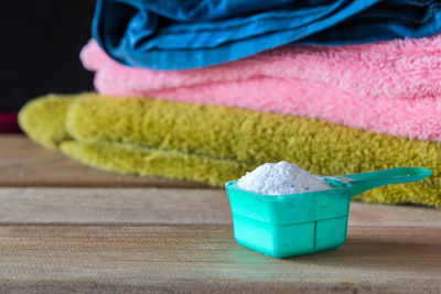 Close-up of laundry detergent and towels on table