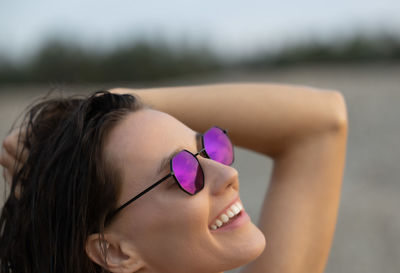 Close-up of young woman wearing sunglasses against sky
