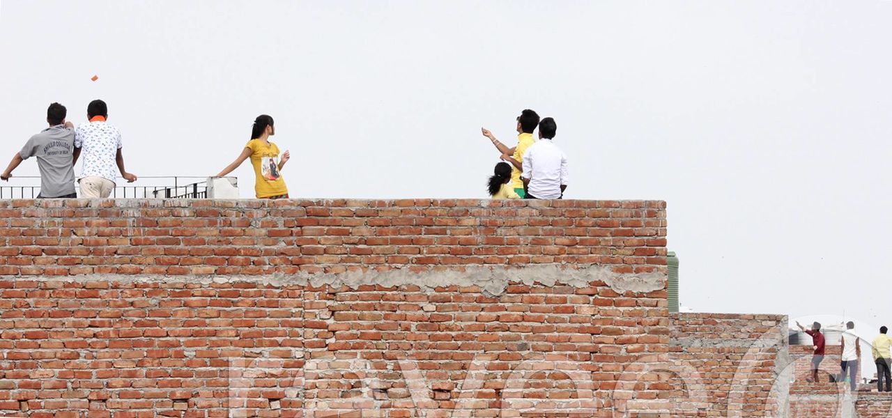 LOW ANGLE VIEW OF WOMAN STANDING ON RAILING