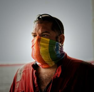 Close-up portrait of man wearing mask against gray background