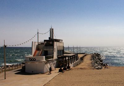 Lifeguard hut on beach against clear sky