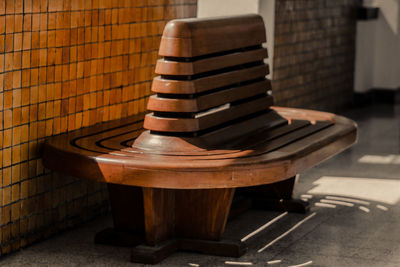 Empty wooden bench on sidewalk