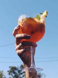 Midsection of man holding ice cream against sky