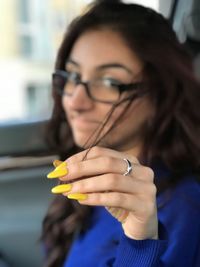 Close-up of young woman holding eyeglasses