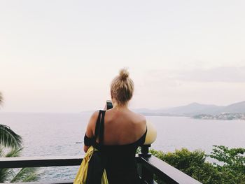 Rear view of woman looking at sea against sky