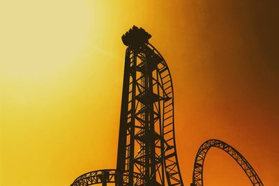 Low angle view of silhouette ferris wheel against sky during sunset