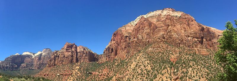 Low angle view of rocky mountain against blue sky