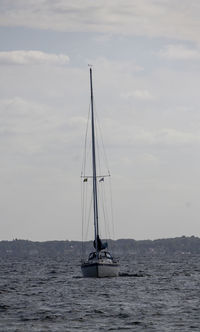 Sailboat sailing on sea against sky