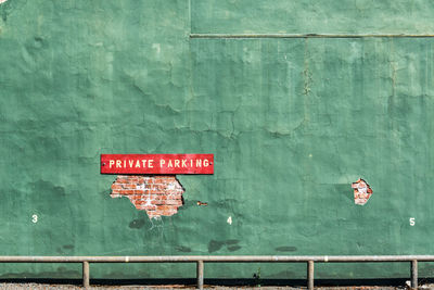 Private parking sign on green wall