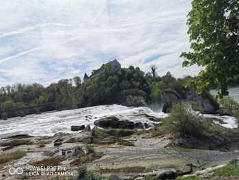 Scenic view of waterfall against sky