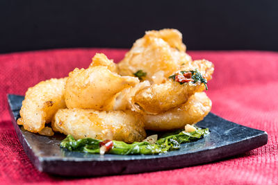 Close-up of fried food on table against black background