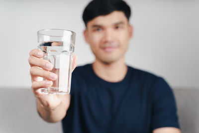 Portrait of young man drinking glass