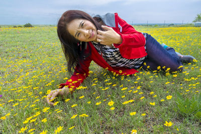 Young woman with yellow flowers on field